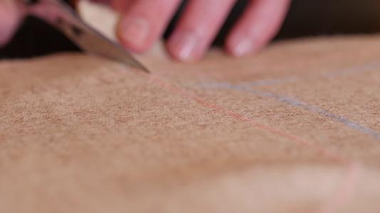 用剪刀切割米色天然粗花呢面料的特写缝纫教程视频的预览图