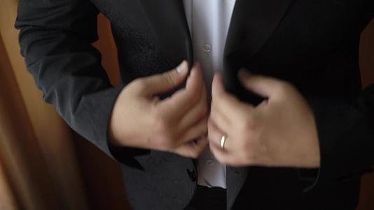 年轻男子穿上夹克和外套庆祝商务会议或婚礼视频的预览图