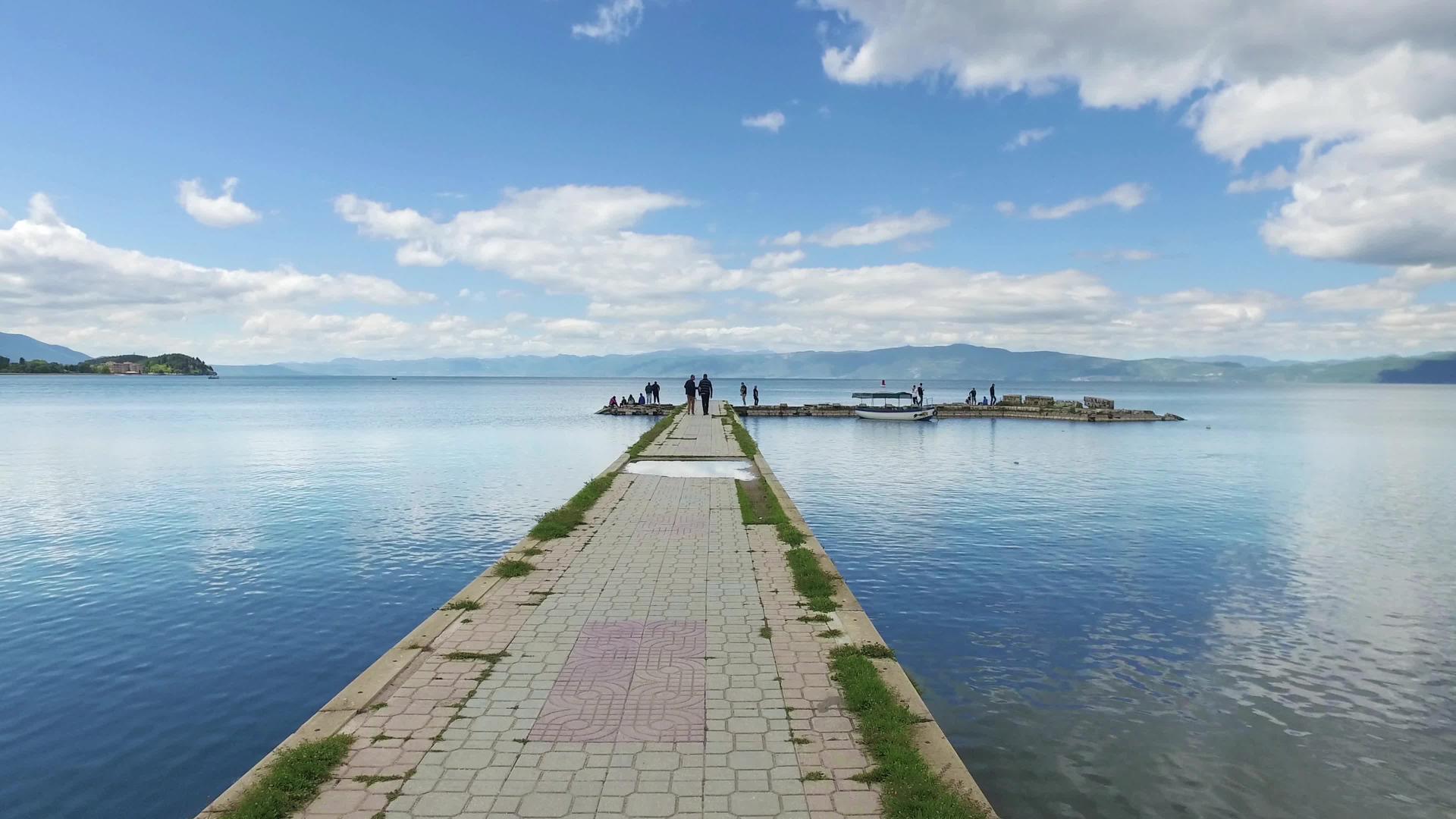 在奥赫里德湖的渔夫港有平静的水反射和蓝天视频的预览图