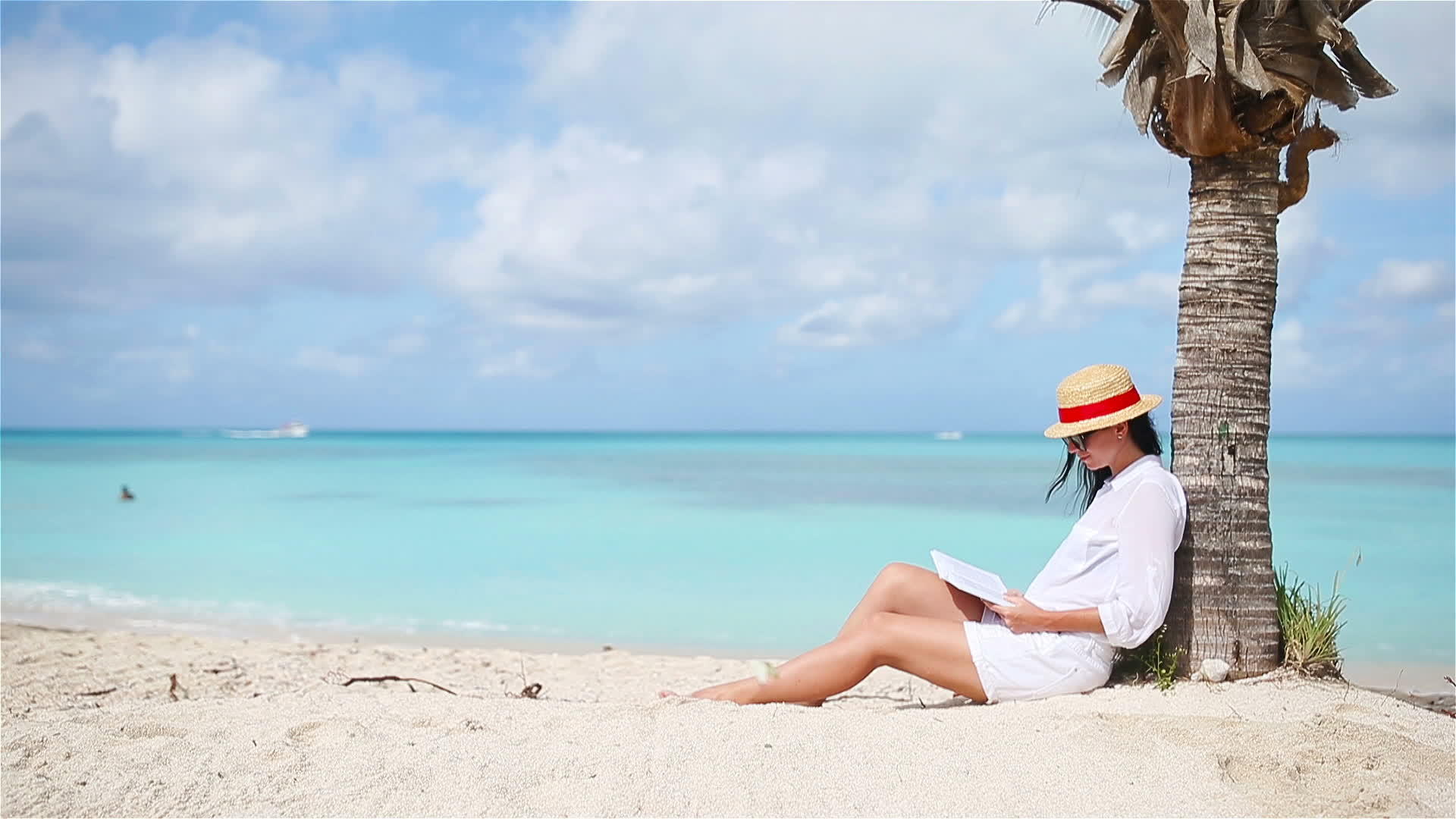 年轻女子在热带白沙滩上读书视频的预览图
