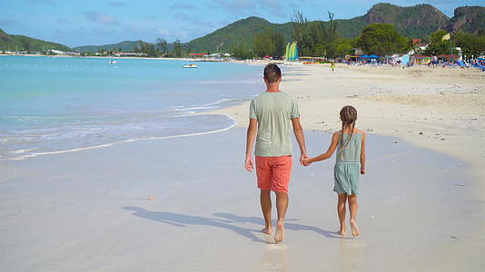 小女孩和爸爸在热带沙滩度假视频的预览图