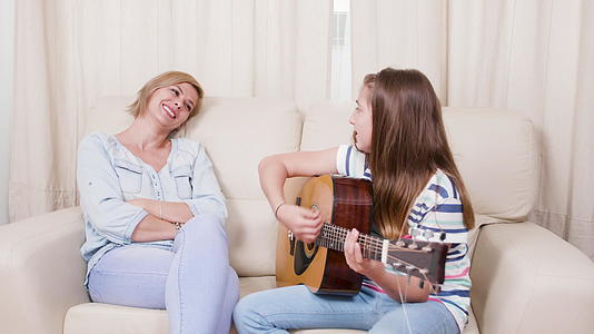 女孩在吉他上给妈妈唱了一首歌视频的预览图
