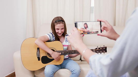 她的母亲制作了一段她年轻女儿演奏的音乐吉他的视频视频的预览图