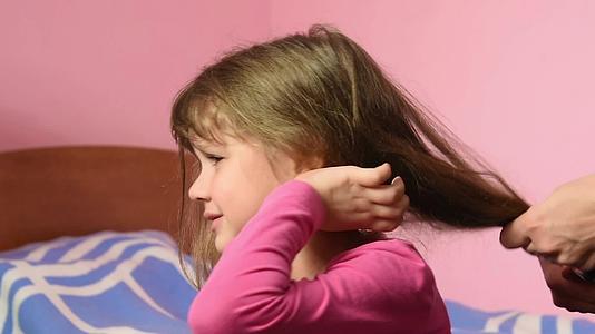 当母亲把头发梳在一起时女孩伤得很重视频的预览图