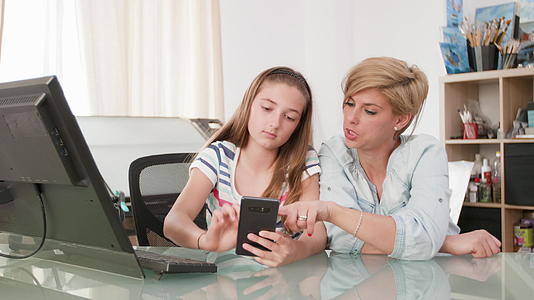 年轻女孩用智能手机向母亲展示一些东西视频的预览图