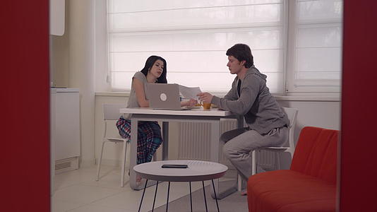 妇女和男子在公寓里使用笔记本电脑视频的预览图