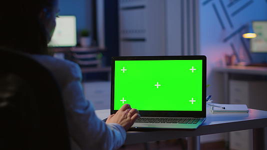 晚上女性用绿色模型看笔记本电脑视频的预览图