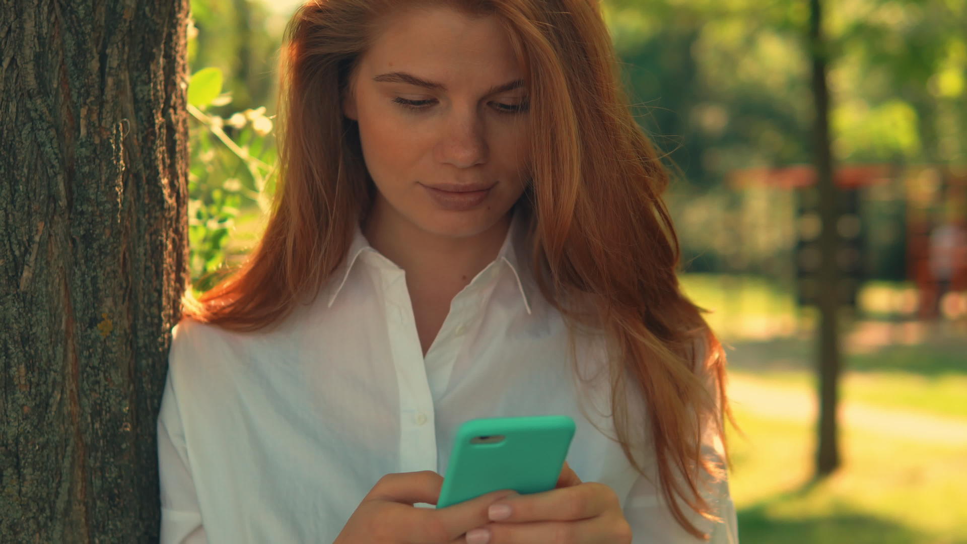 在公园里使用智能手机的成年女性肖像视频的预览图