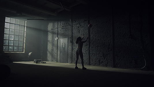 女性健美运动员用球靠墙做深蹲视频的预览图
