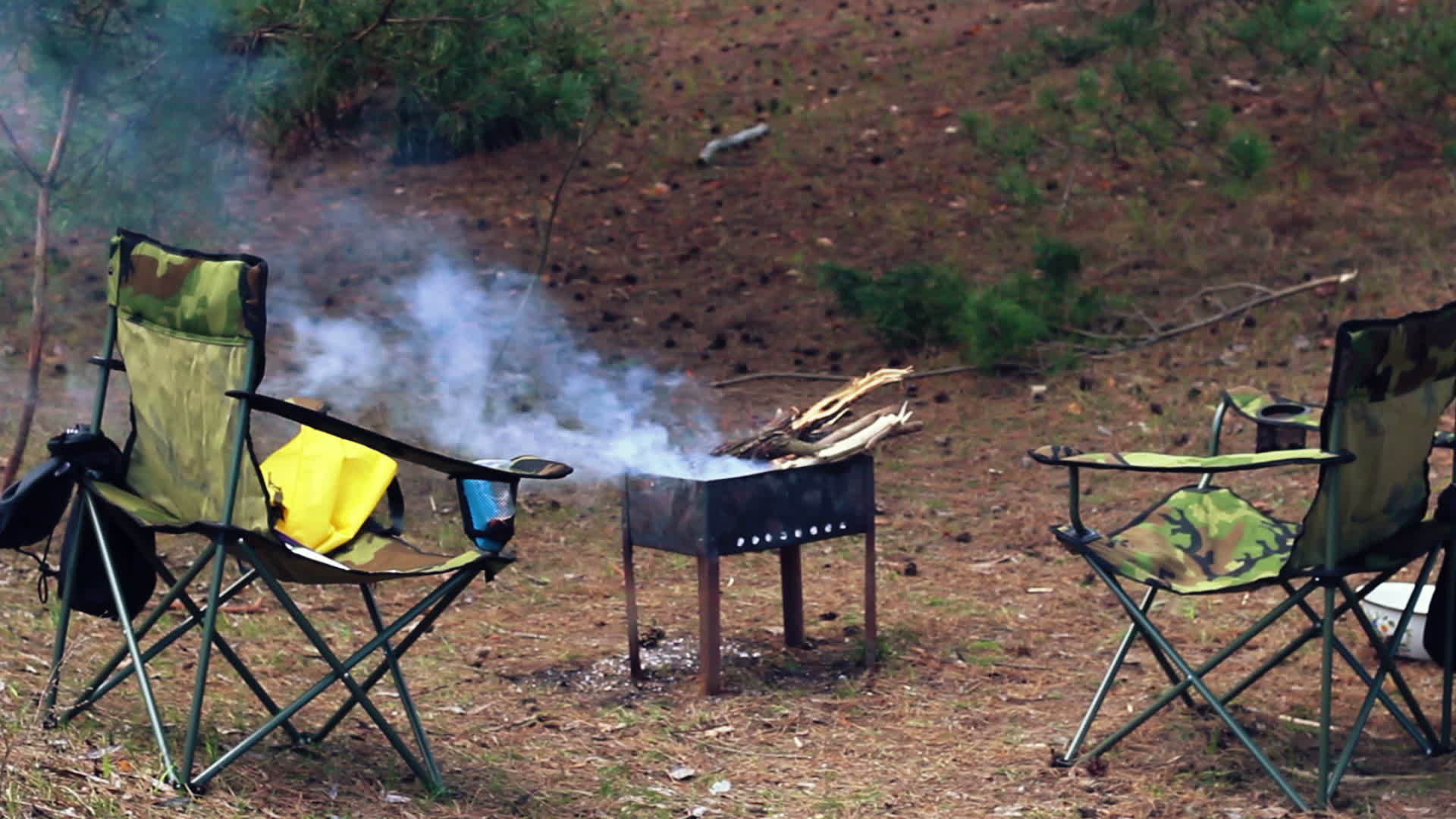 在森林里露营的地方森林里的露营椅和烧烤视频的预览图