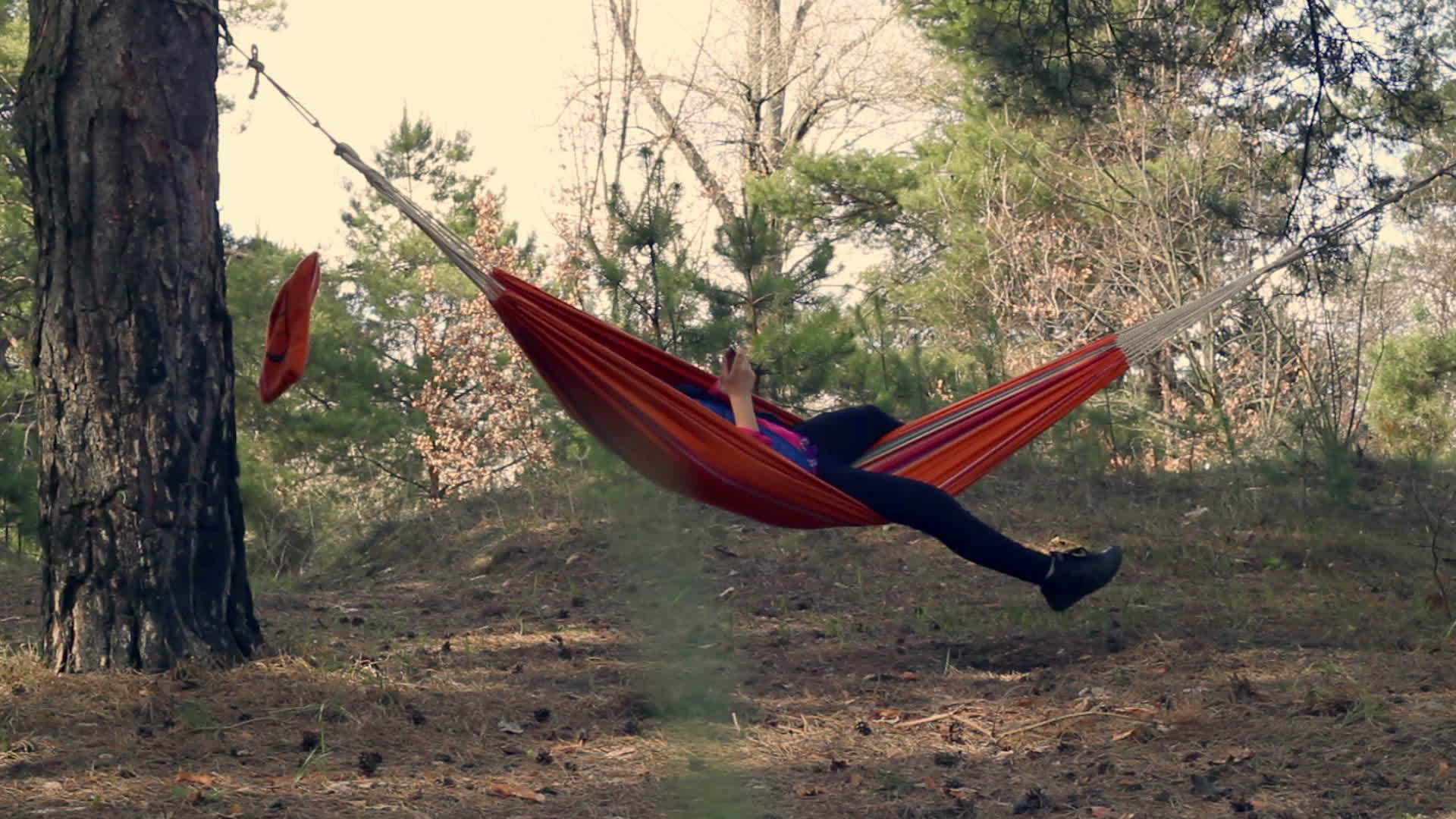 春季休闲林中吊床上的年轻女子户外娱乐视频的预览图