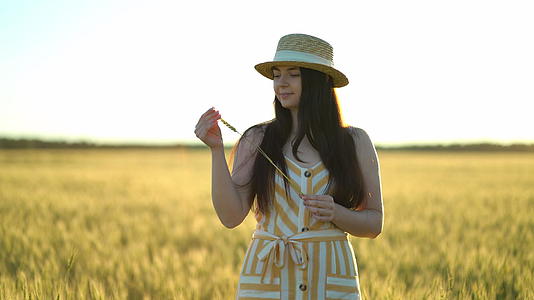 美丽的年轻女士戴着帽子手里拿着小麦视频的预览图