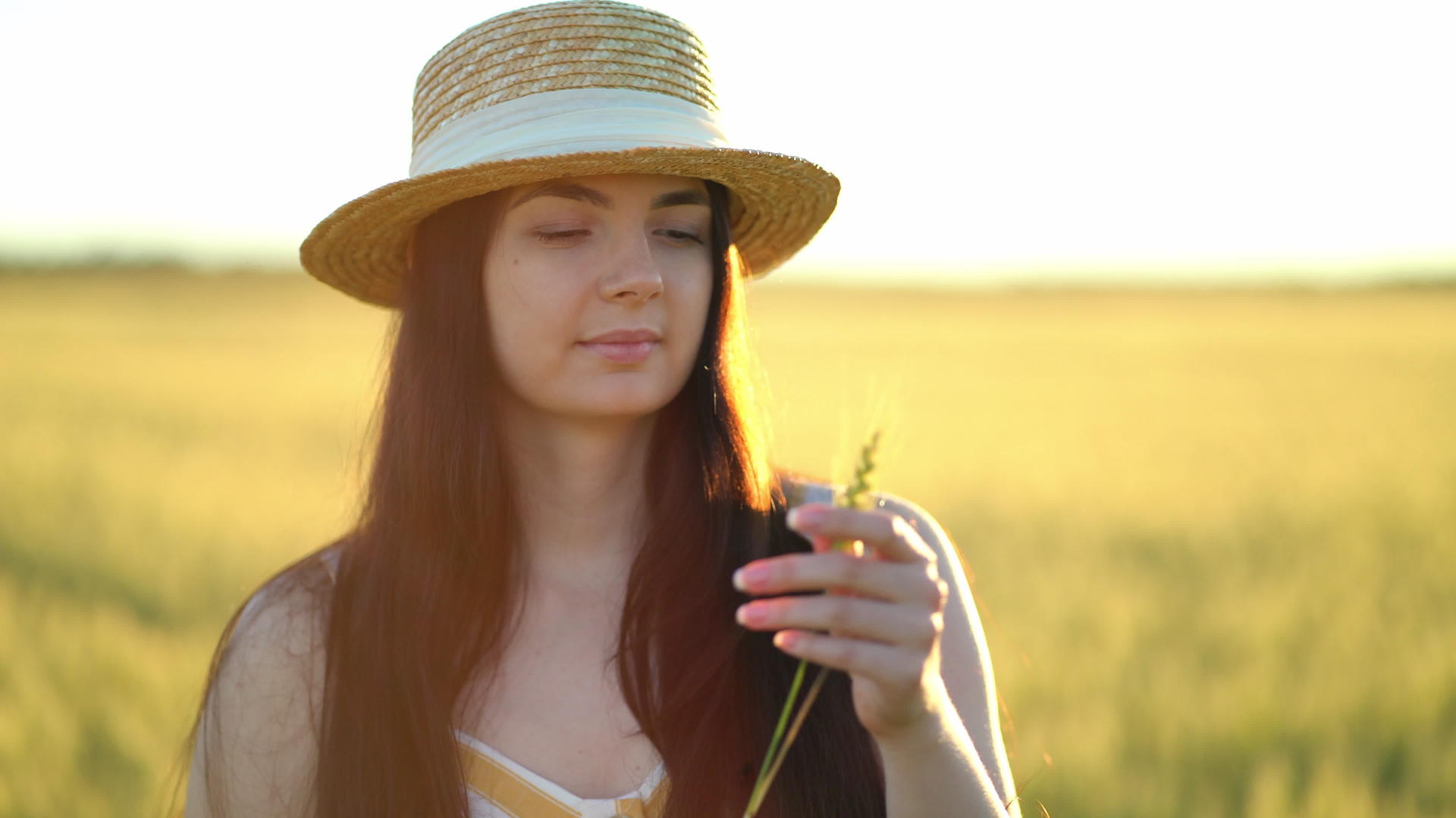 美丽的年轻女士戴着帽子手里拿着小麦耳朵视频的预览图