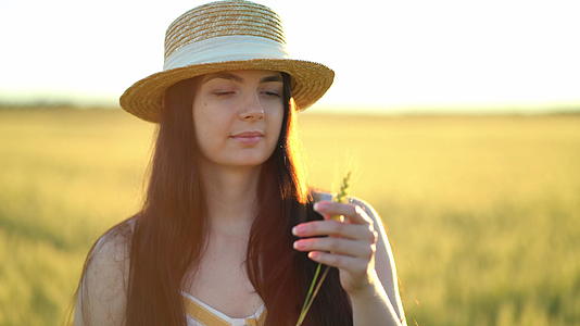 美丽的年轻女士戴着帽子手里拿着小麦耳朵视频的预览图