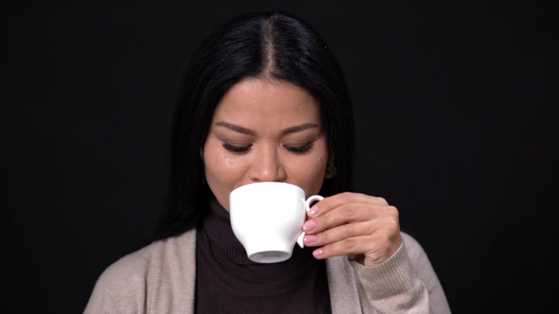 黑发女人用白杯子喝咖啡视频的预览图