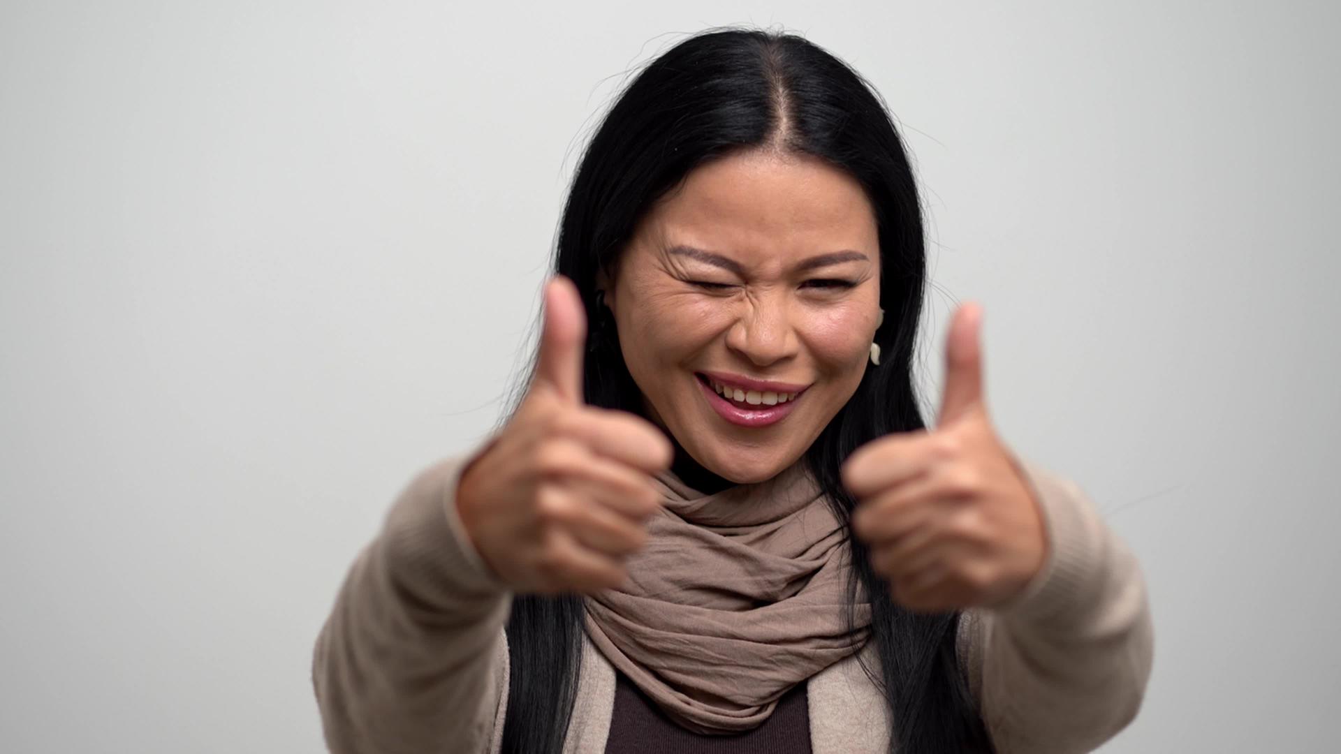 快乐的亚洲女人狭隘地盯着白色背景视频的预览图