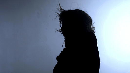 一位头发随风飘扬的年轻女性黑影视频的预览图