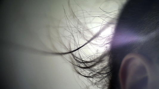 男人的头发在阳光下随风飘扬视频的预览图