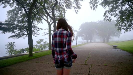 女孩在公园雾中行走女孩在雾中行走视频的预览图