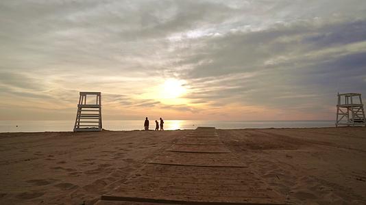 日落时在海滩上散步视频的预览图