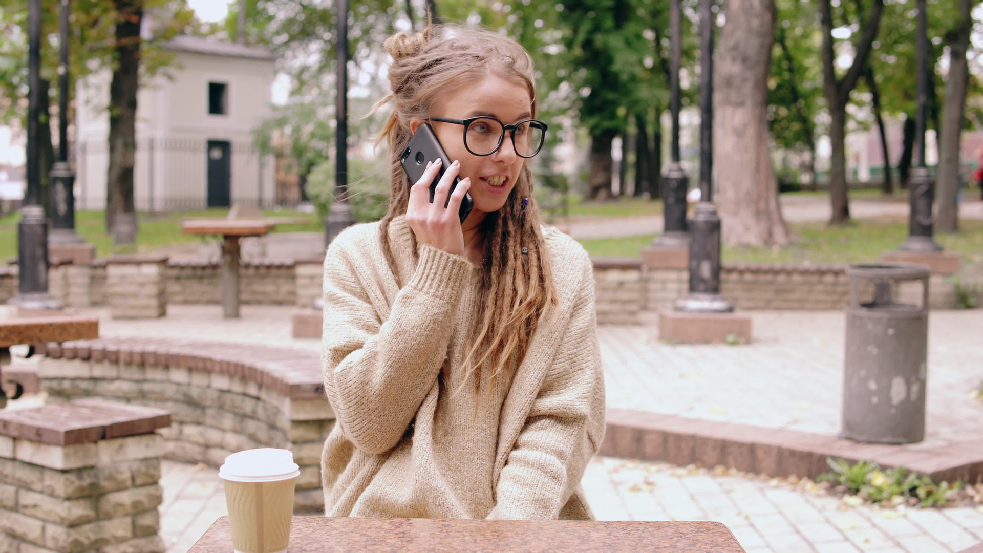 微笑的女孩在公园里用手机聊天视频的预览图