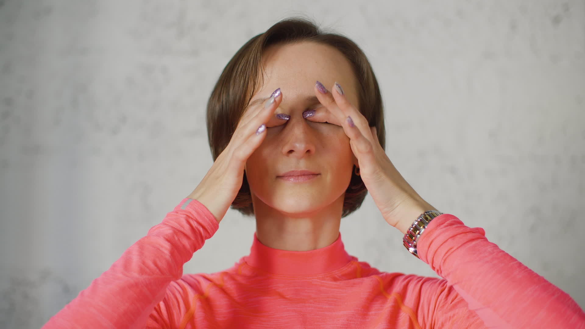 年轻女性用手指在光线背景上闭上眼睛视频的预览图