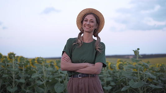 女农民站在农业向日葵田白种女农民草帽肖像农业综合农业视频的预览图