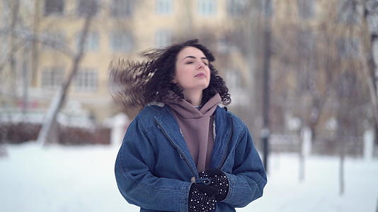 快乐的年轻女子在冬天的城市里视频的预览图