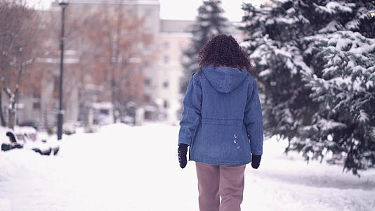 冬天的城市里快乐的年轻女子留着卷发视频的预览图