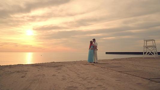 日落时在海边接吻爱情夫妻在海边拥抱视频的预览图