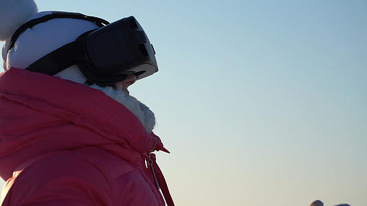 女孩冬天在户外看虚拟现实护目镜视频的预览图