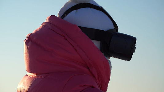 女孩冬天在户外看虚拟现实护目镜视频的预览图