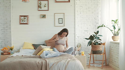 怀孕的母亲抚摸她的胃来缓解腹痛视频的预览图