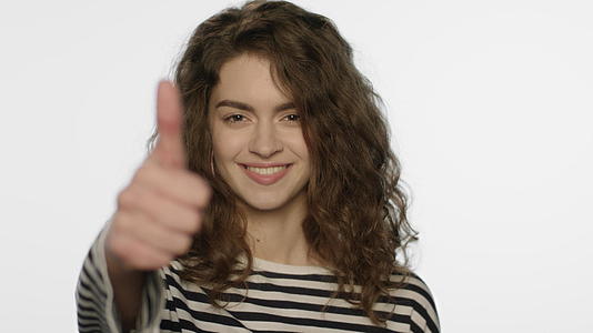 面对镜头白色背景平面美女模特竖起大拇指视频的预览图