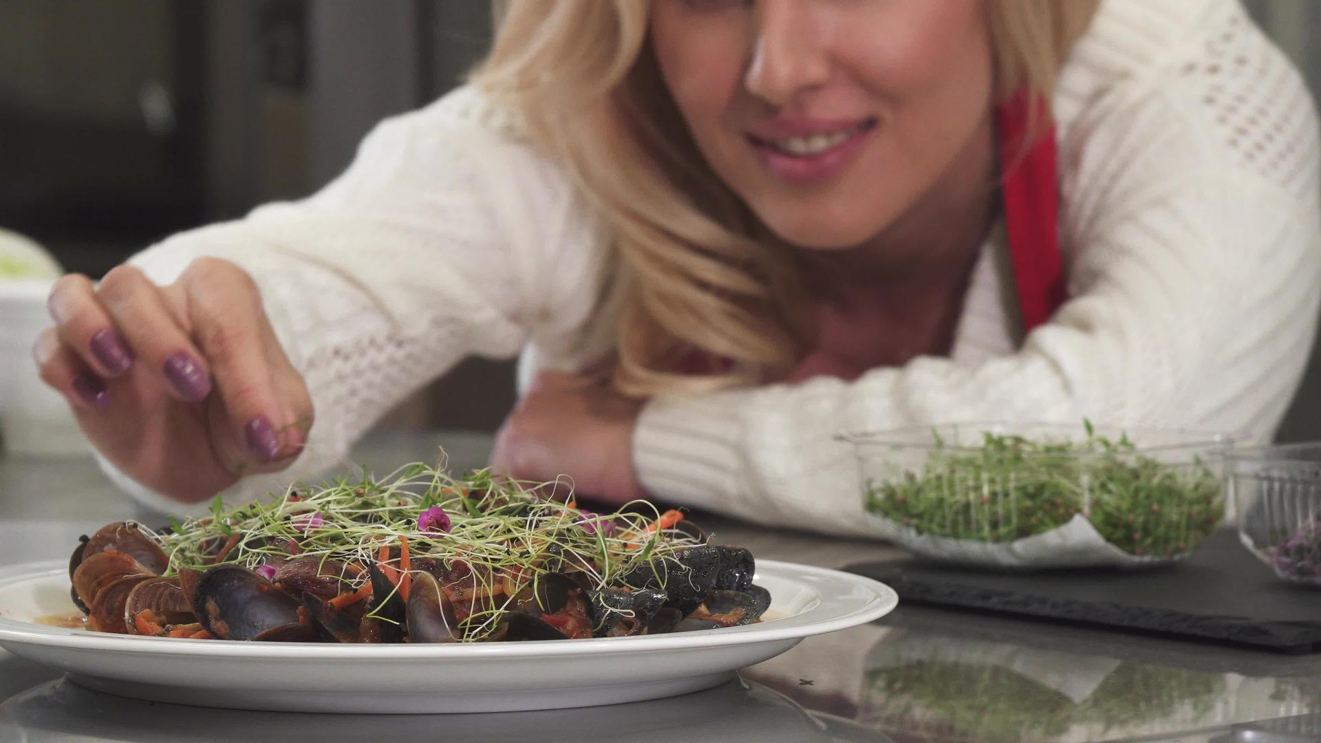 漂亮的女人在餐盘上装饰贝贝的菜盘在家做饭视频的预览图