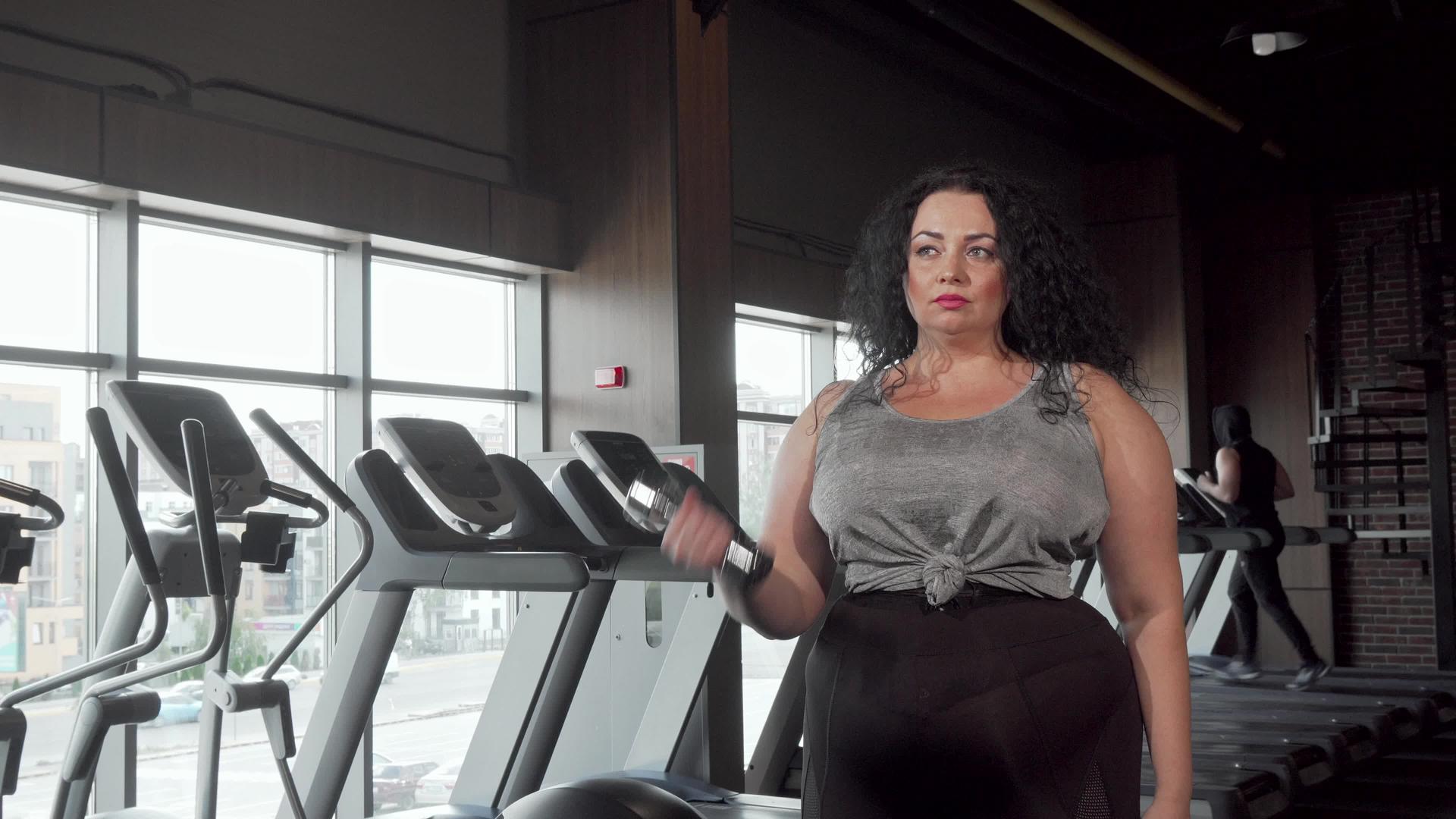 在健身房用哑铃做运动的美女视频的预览图