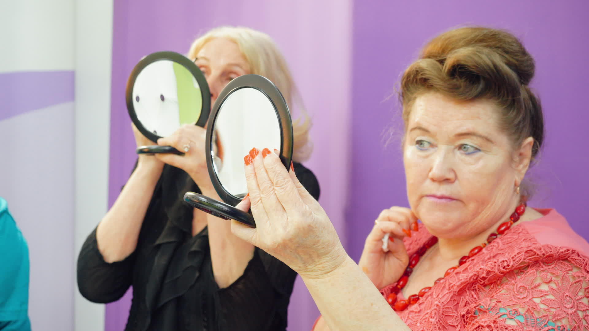 上化妆课的老年妇女看着镜子尝试新技能视频的预览图