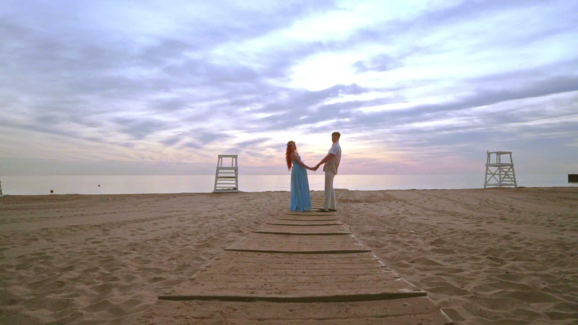 情侣在海边握手情侣在海边日出视频的预览图