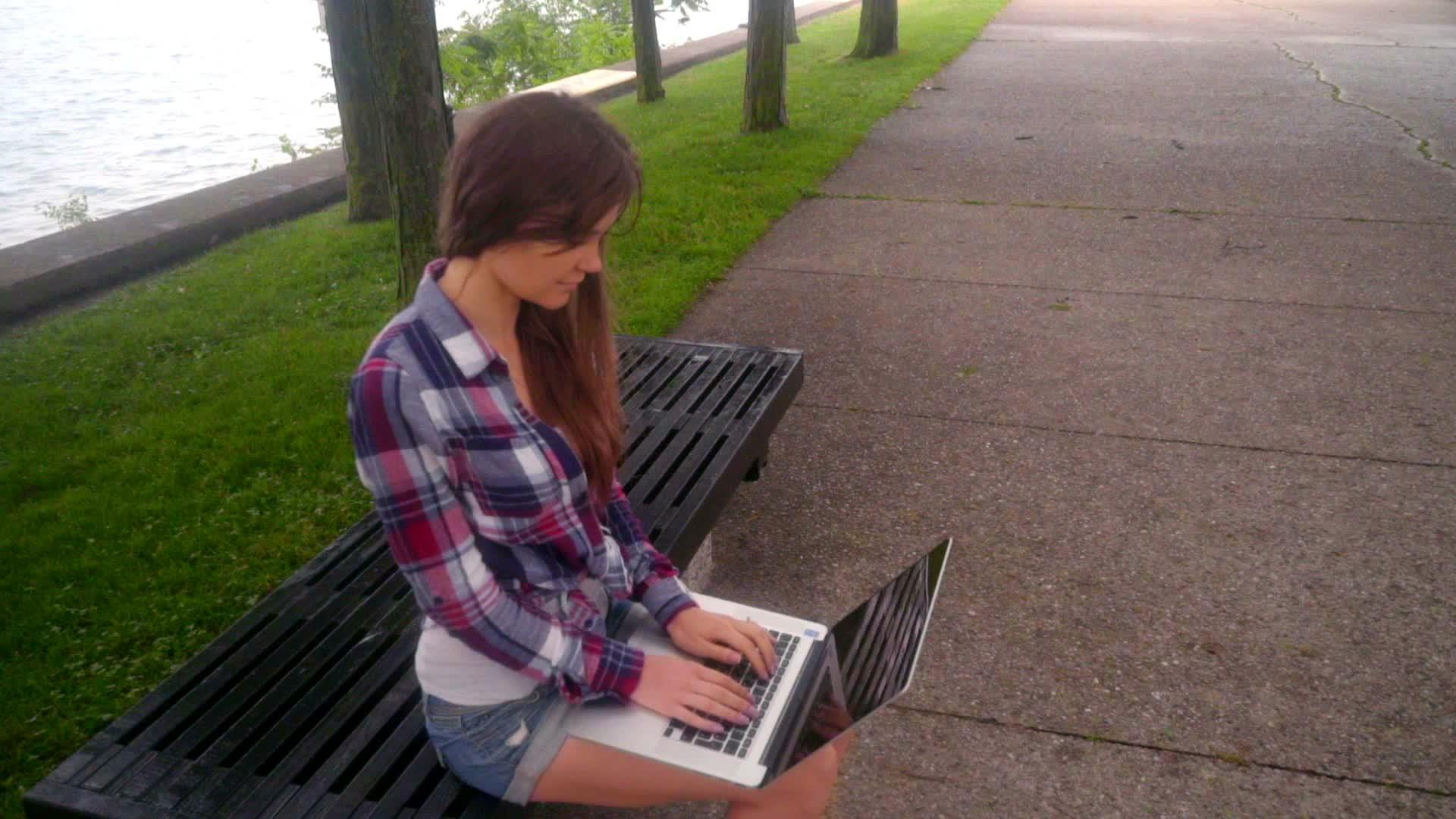 年轻女性玩笔记本电脑女孩在外面用笔记本电脑女人在外面用笔记本电脑视频的预览图
