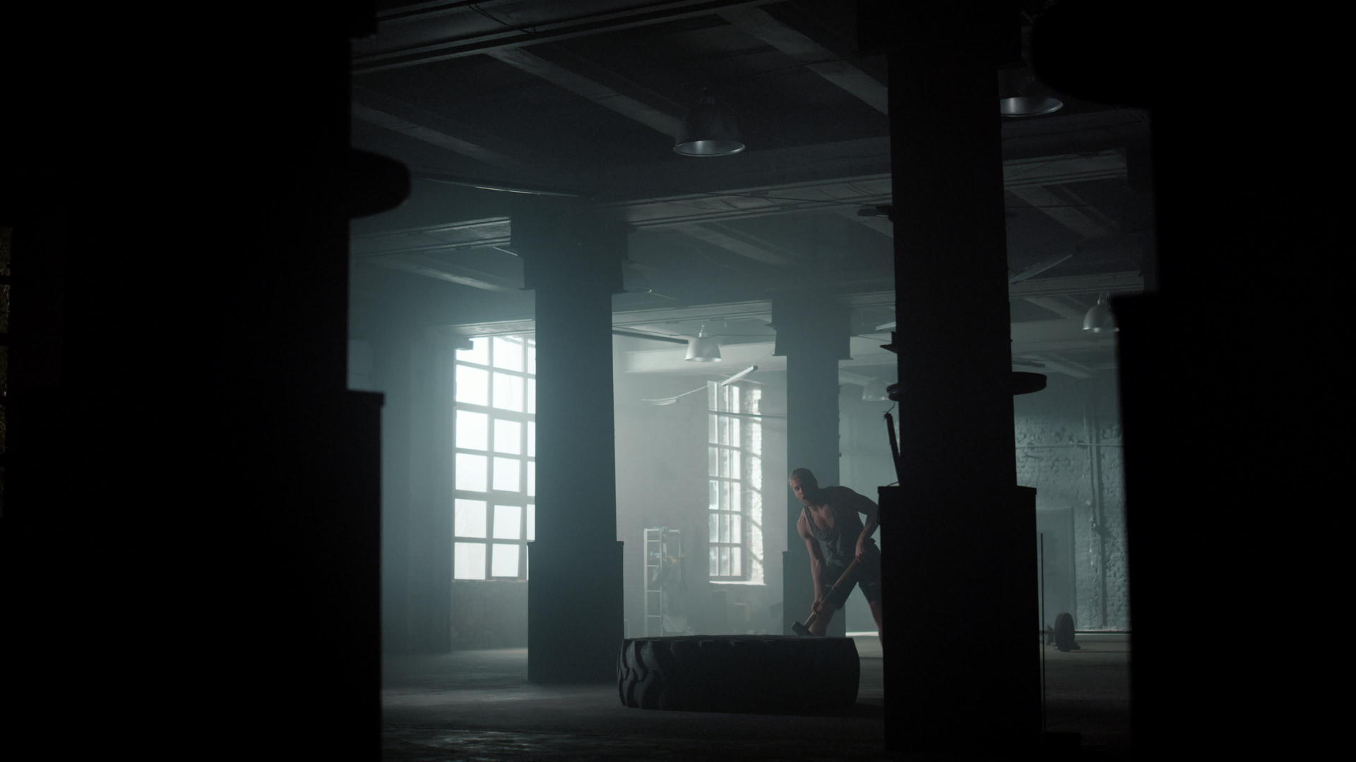在阁楼建筑中健身男子用锤子敲打橡胶轮胎进行力量训练视频的预览图