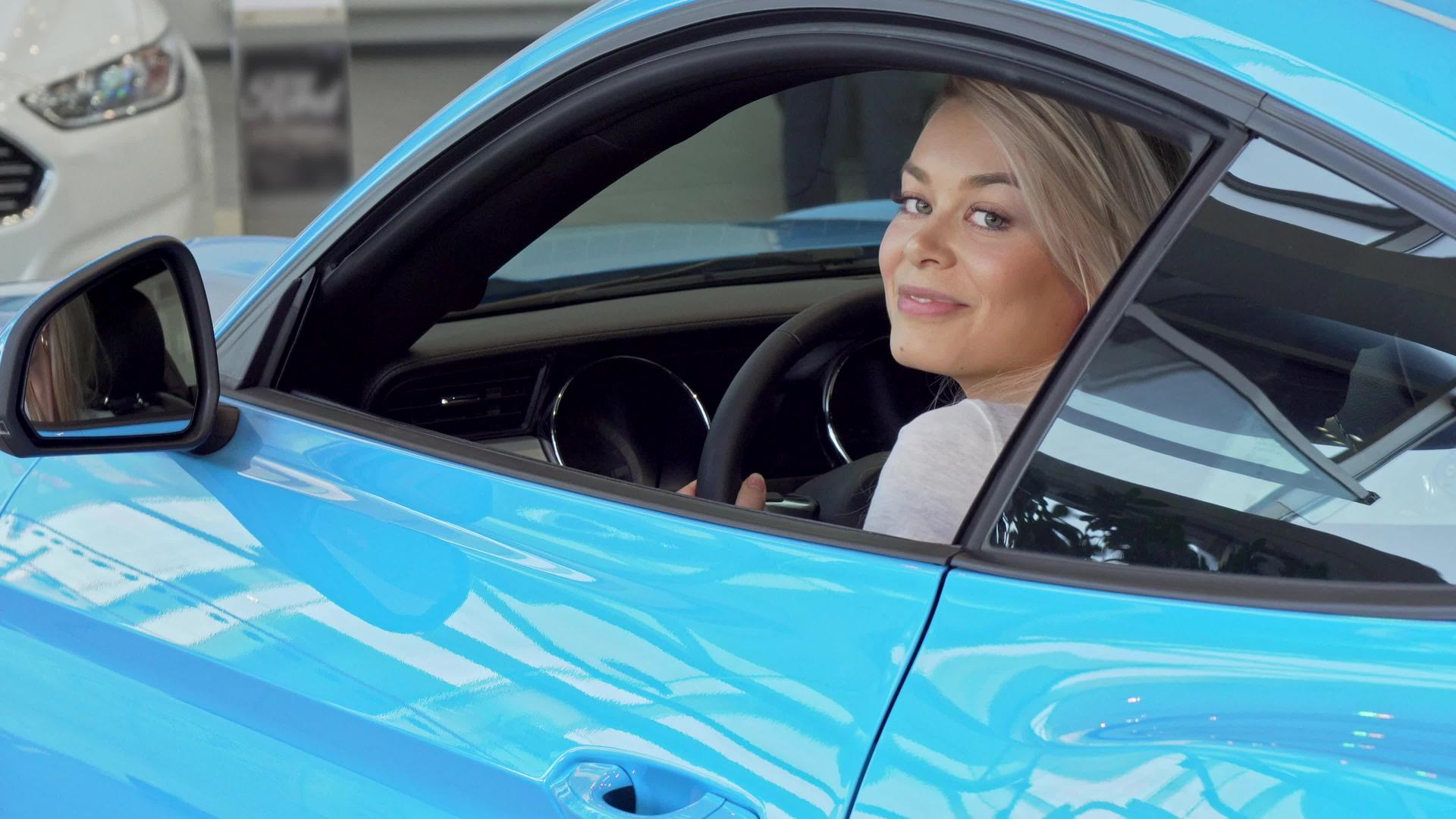 快乐美丽的女人微笑着坐在一辆新车上视频的预览图