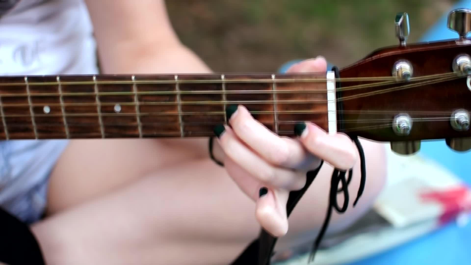 一个修指甲的女人手里拿着吉他和弦女孩在大自然中弹奏视频的预览图