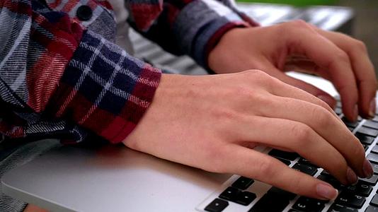 女性手机在膝上型电脑键盘打字视频的预览图