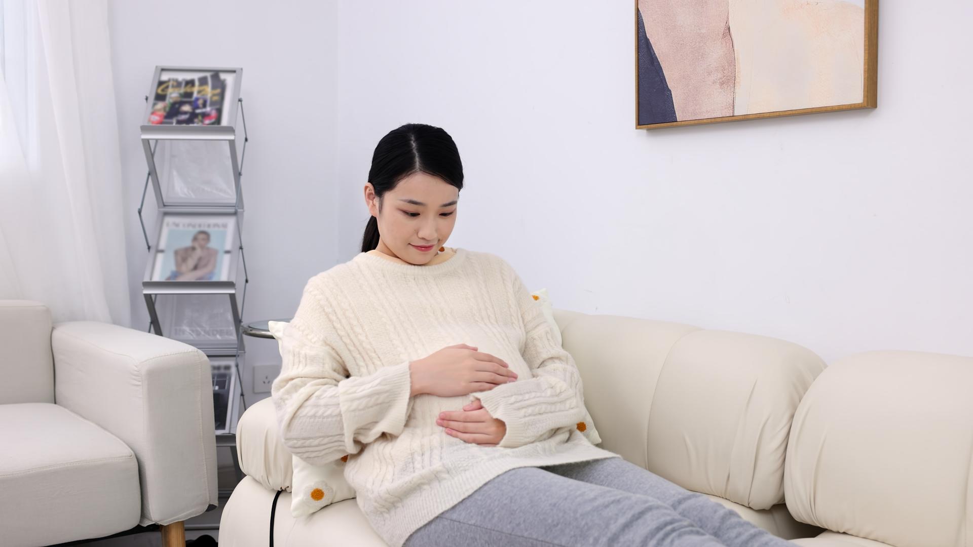 居家孕妇坐在沙发上抚摸肚子视频的预览图