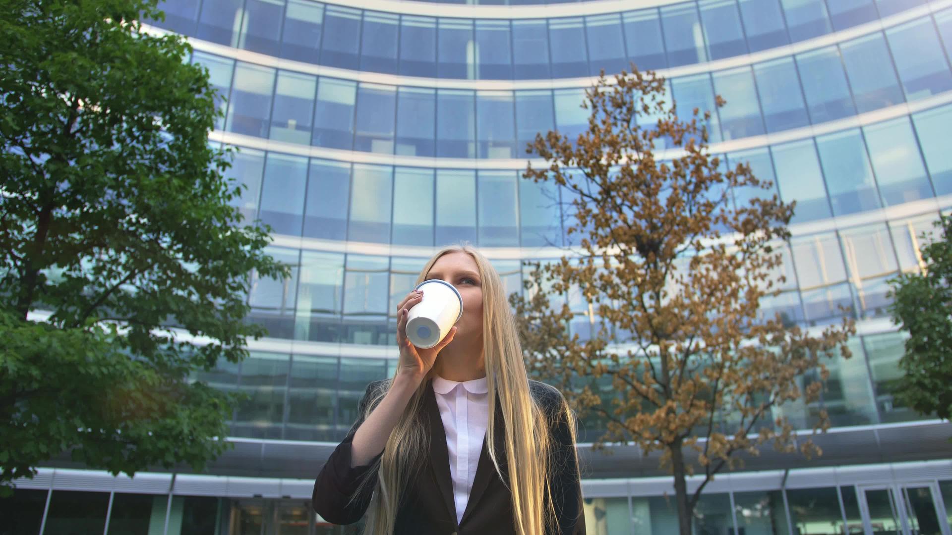 时尚的商业女郎在街上喝咖啡视频的预览图