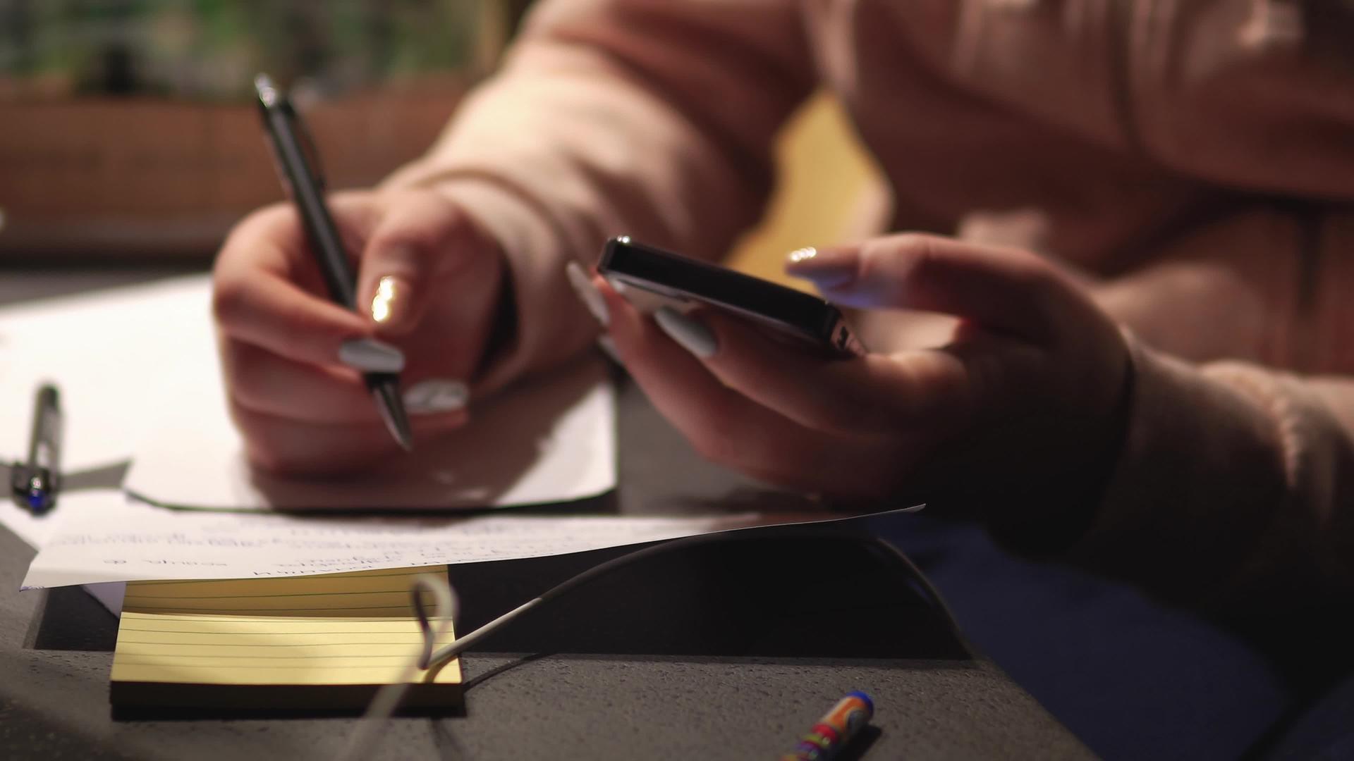女人用她的智能手机写和计算家庭账单视频的预览图