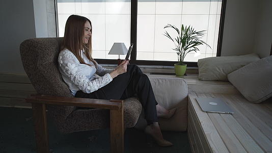 一位商业女商人坐在扶手椅上进行在线对话视频的预览图