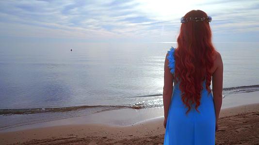 红发女人看着大海后面的女人海滩上的女人视频的预览图