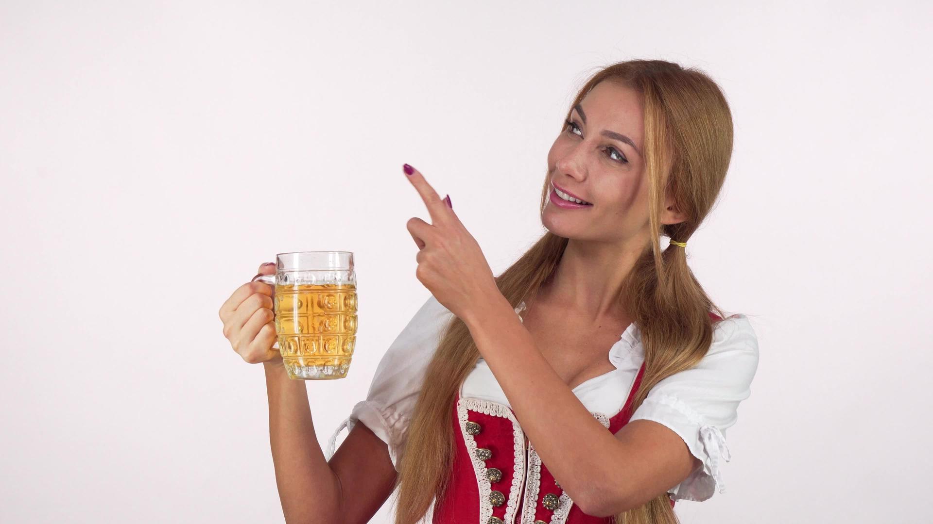 迷人性感的巴伐利亚女人拿着啤酒杯指着复制空间视频的预览图