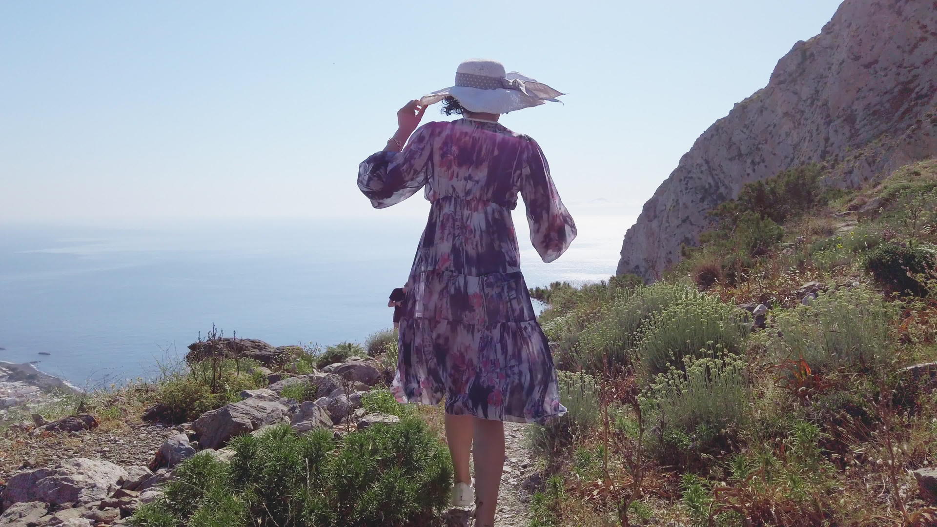 女人走在圣坦托里尼路上在古代神话中的海边漫步视频的预览图